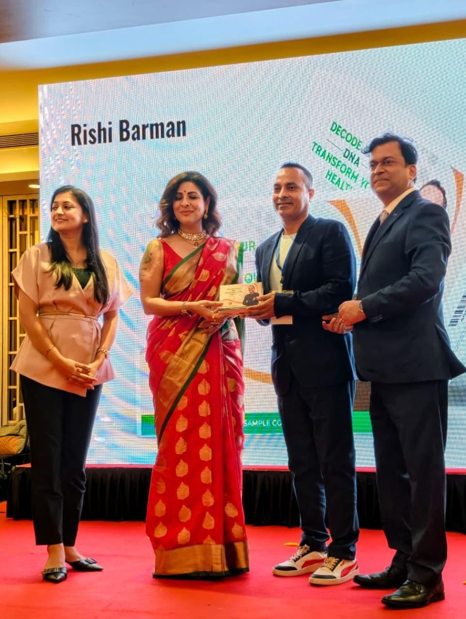 Rrishi Barman being felicitated on stage at the Welocity Institute of Genomics