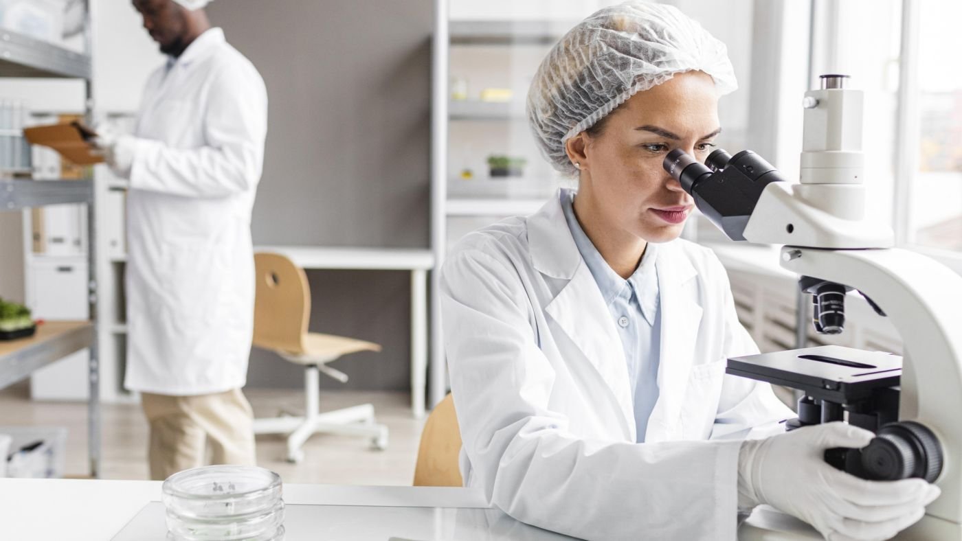A laboratory scientist examining a sample under a microscope