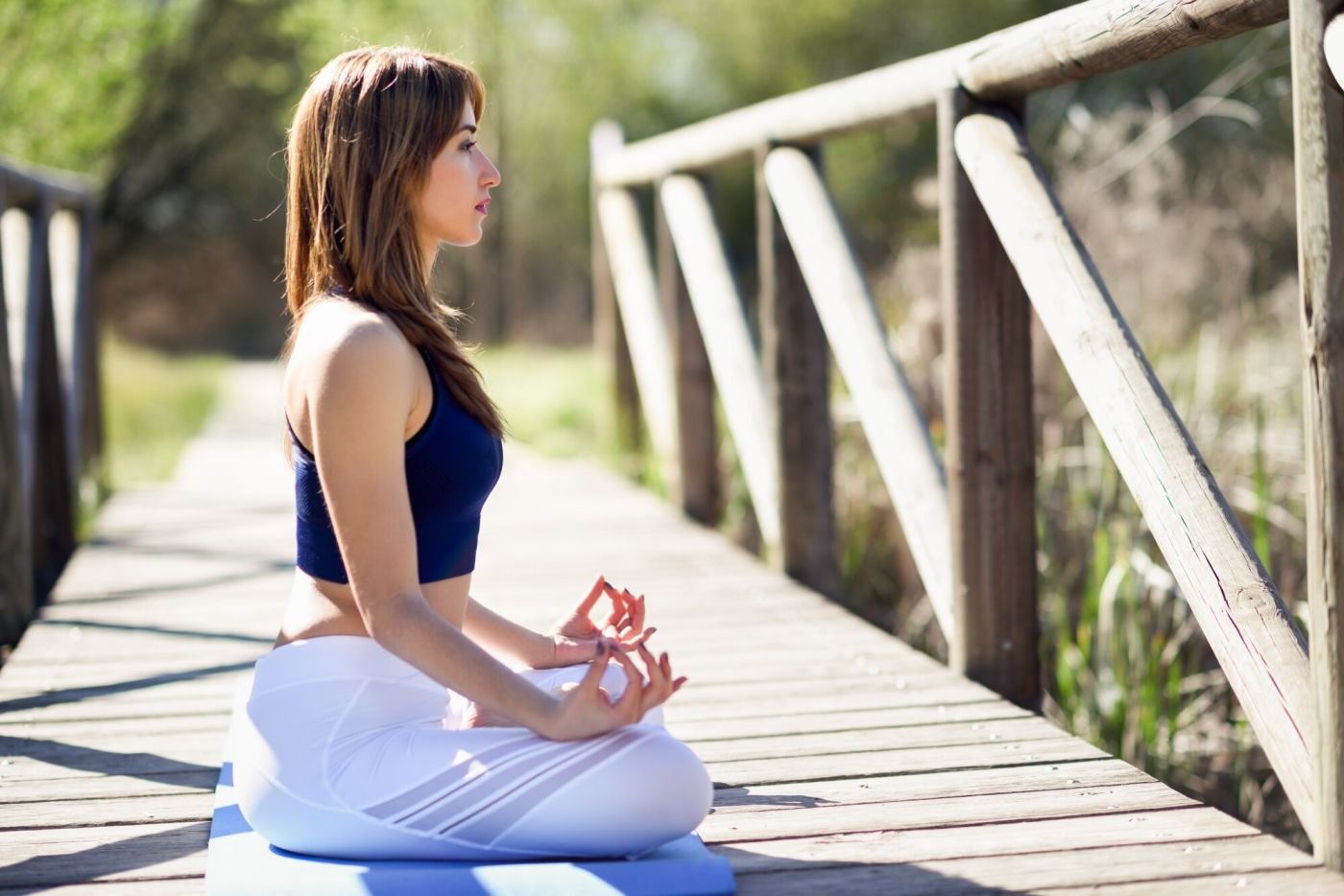 A woman practising yoga outdoors in morning light